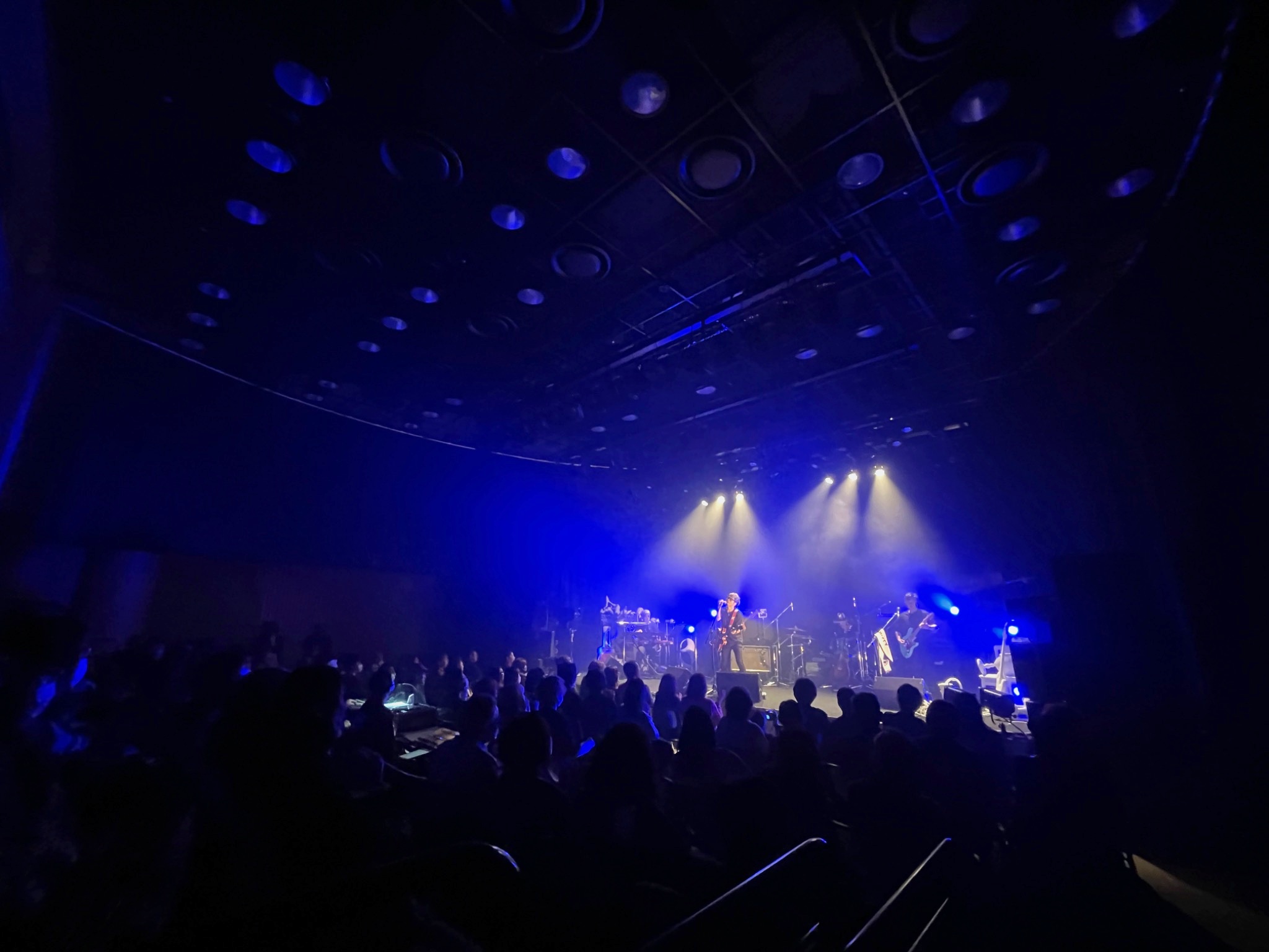 青い照明に包まれたホールのライブ風景